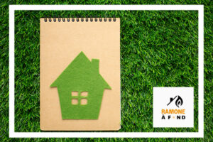 Un carnet avec une illustration d’une maison verte sur un fond de pelouse, symbolisant une rénovation écologique et éco-responsable.